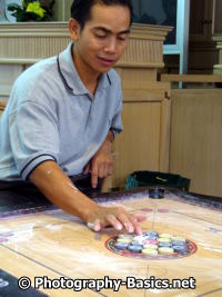 Using the gaze as well as the hand and lines on the carrom board creates a focal point photography on the carrom men.